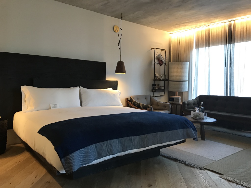 MADE Hotel More angles in the bedroom, floating bed, wooden floor, exposed concrete ceiling and denim style furnishings.